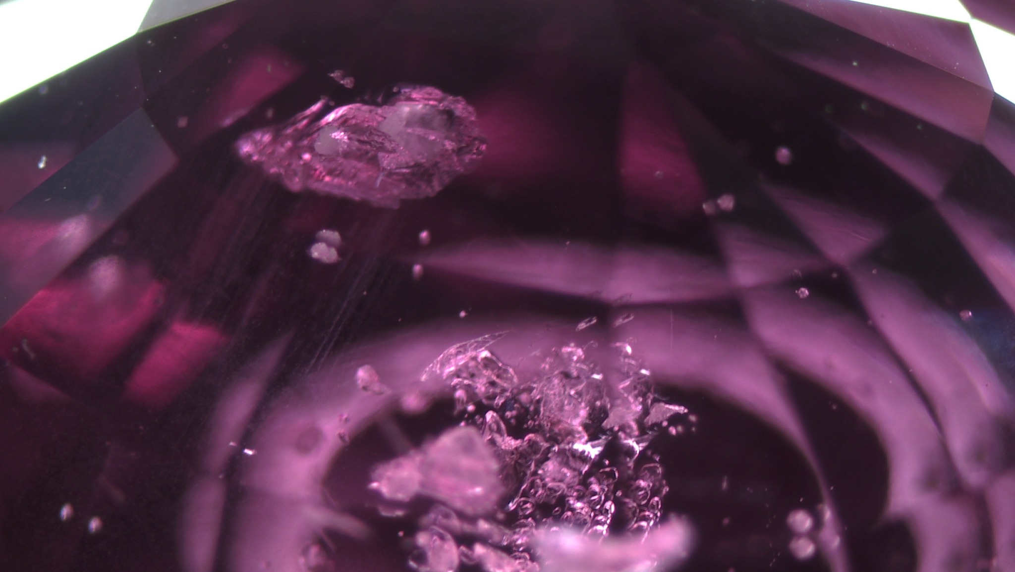 A group of small zircon crystals in an unheated purplish pink sapphire from Madagascar.